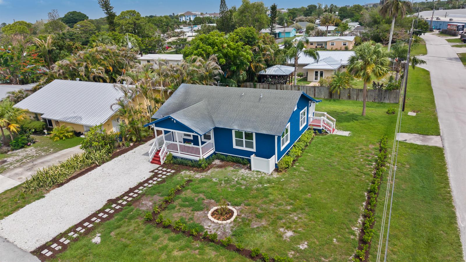 An aerial view of a blue house with a white porch and a gravel driveway — 1566 NW 9th Avenue, Stuart FL 34994, STUART, FL