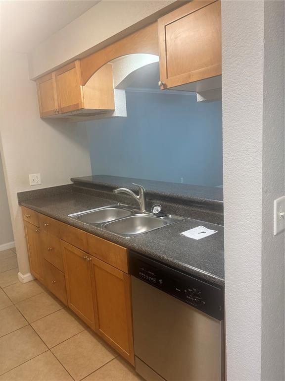 A kitchen features light wood cabinets, a dark countertop, a double sink, and a dishwasher — 10100 SAILWINDS BOULEVARD N UNIT 206, LARGO, FL