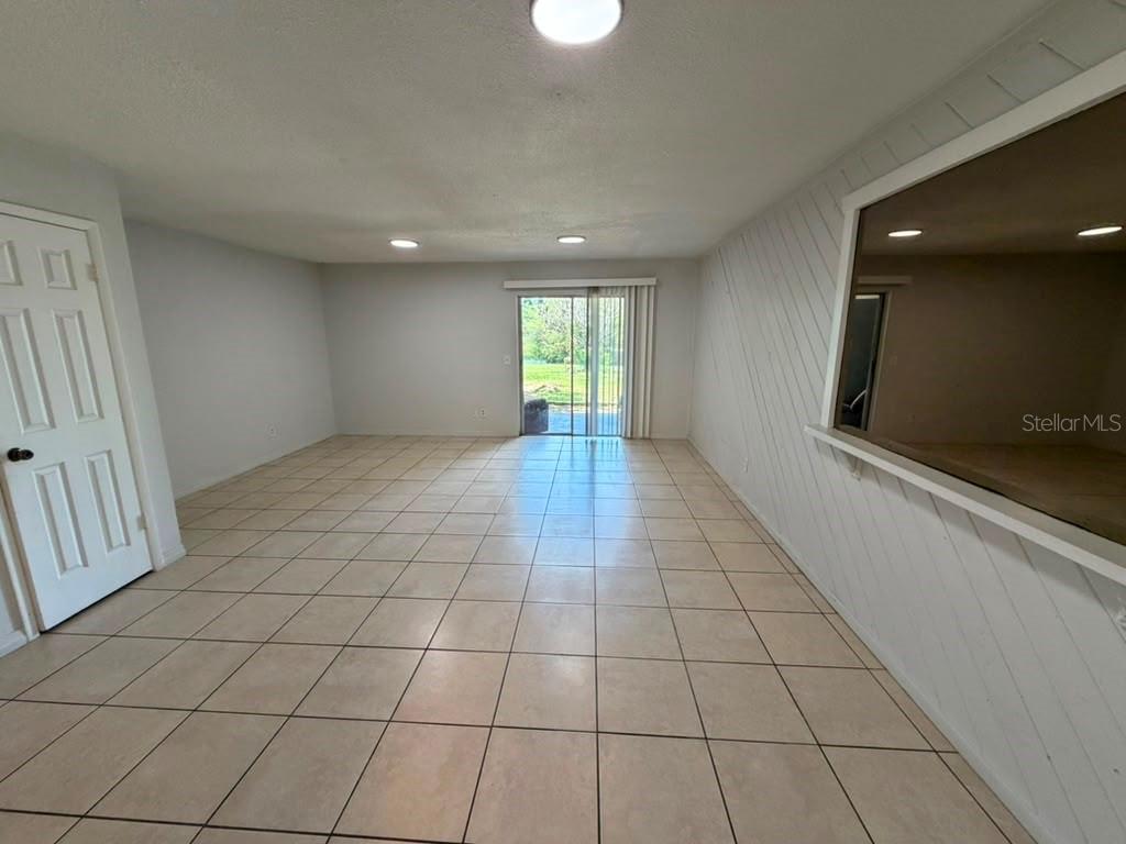 An empty room with light-colored tile flooring, white walls, and a sliding glass door — 2434 RIO PINAR LAKES BOULEVARD, ORLANDO, FL