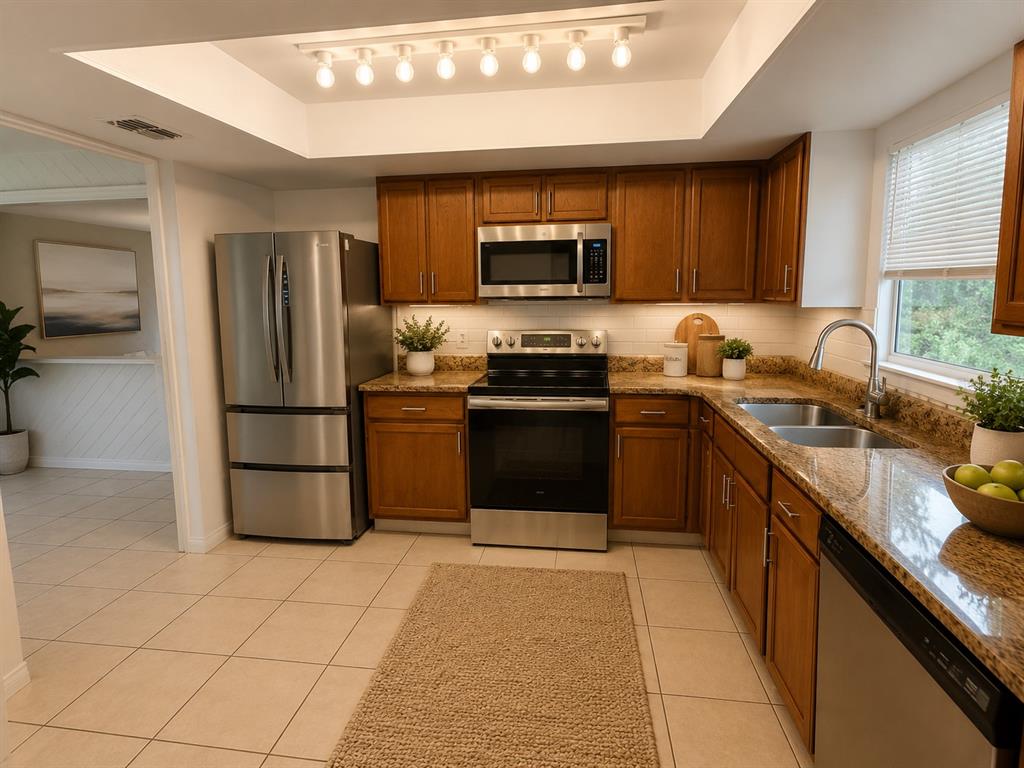 A kitchen features wood cabinets, stainless steel appliances, granite countertops, and a tile floor — 2434 RIO PINAR LAKES BOULEVARD, ORLANDO, FL