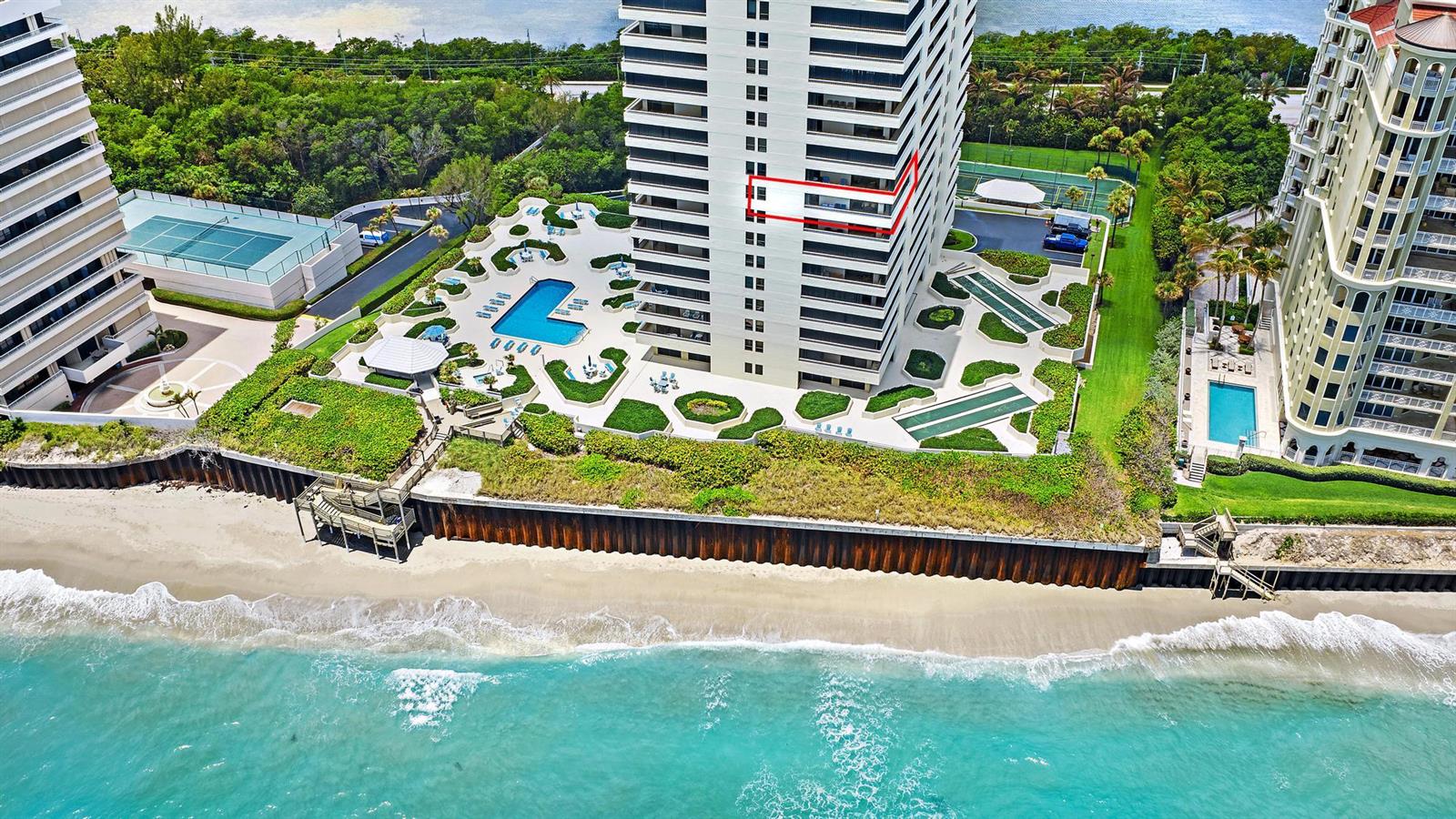 An aerial view shows a beachfront high-rise building with a pool deck and tennis courts — 5280 N Ocean Drive # 8b, Riviera Beach FL 33404, RIVIERA BEACH, FL