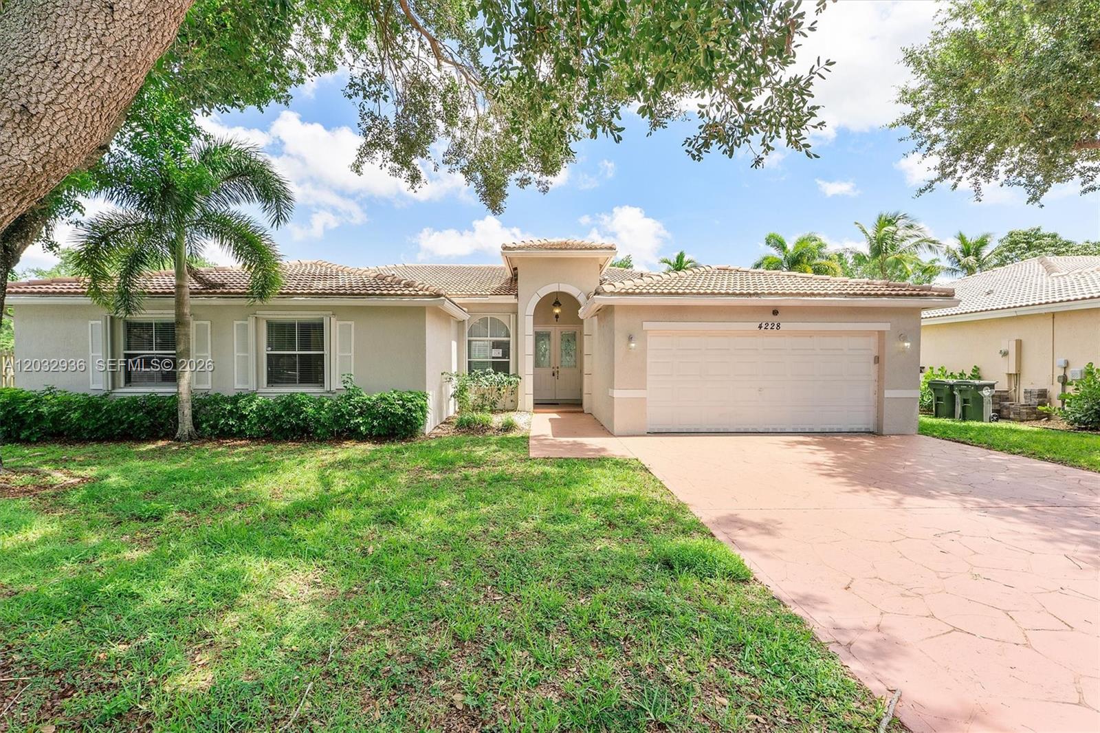 A single-story house features a tiled roof, a two-car garage, and a paved driveway — 4228 NW 41st Ln, Coconut Creek FL 33073, COCONUT CREEK, FL