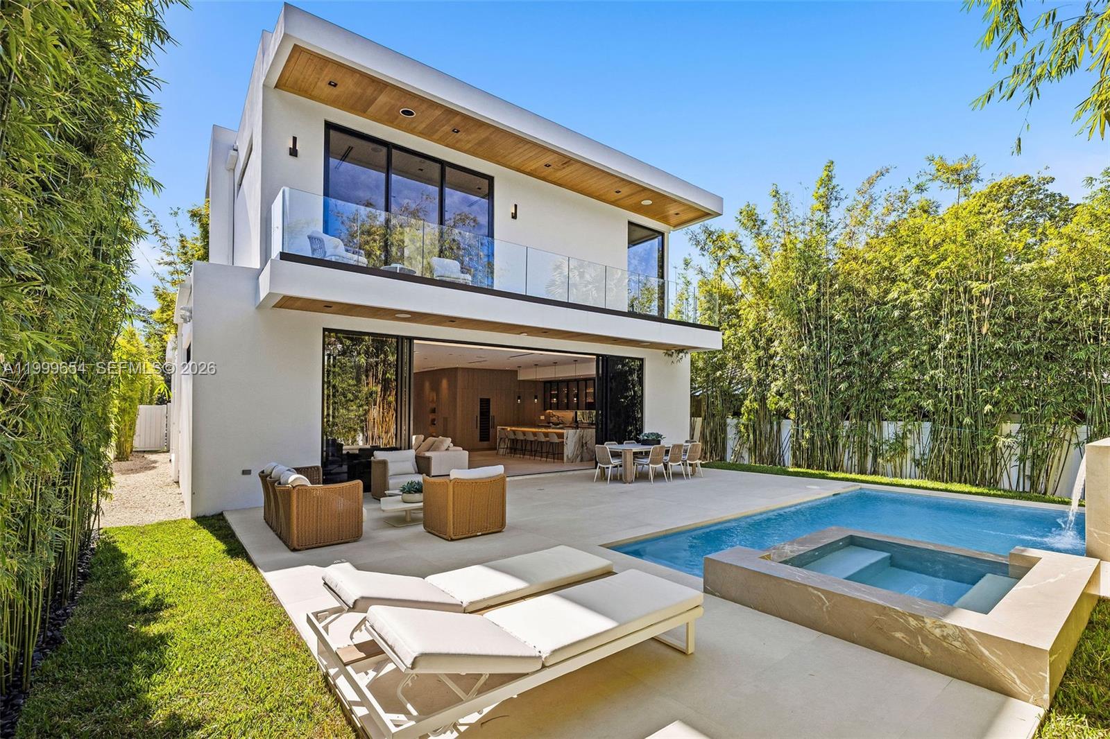 A modern two-story house features a patio, swimming pool, hot tub, and bamboo landscaping — 325 W 63rd St, Miami Beach FL 33141, MIAMI BEACH, FL