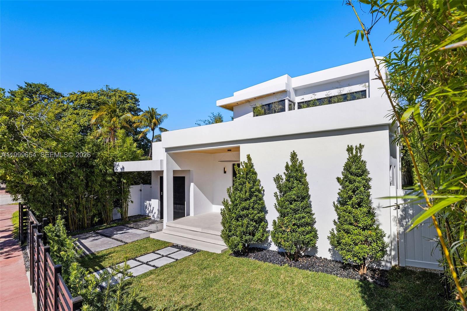 A modern white two-story house features a front porch, landscaping, and a paved walkway — 325 W 63rd St, Miami Beach FL 33141, MIAMI BEACH, FL