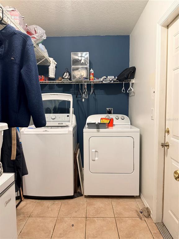 A laundry room features a white washer and dryer against a dark blue wall — 1104 67TH AVENUE W, BRADENTON, FL