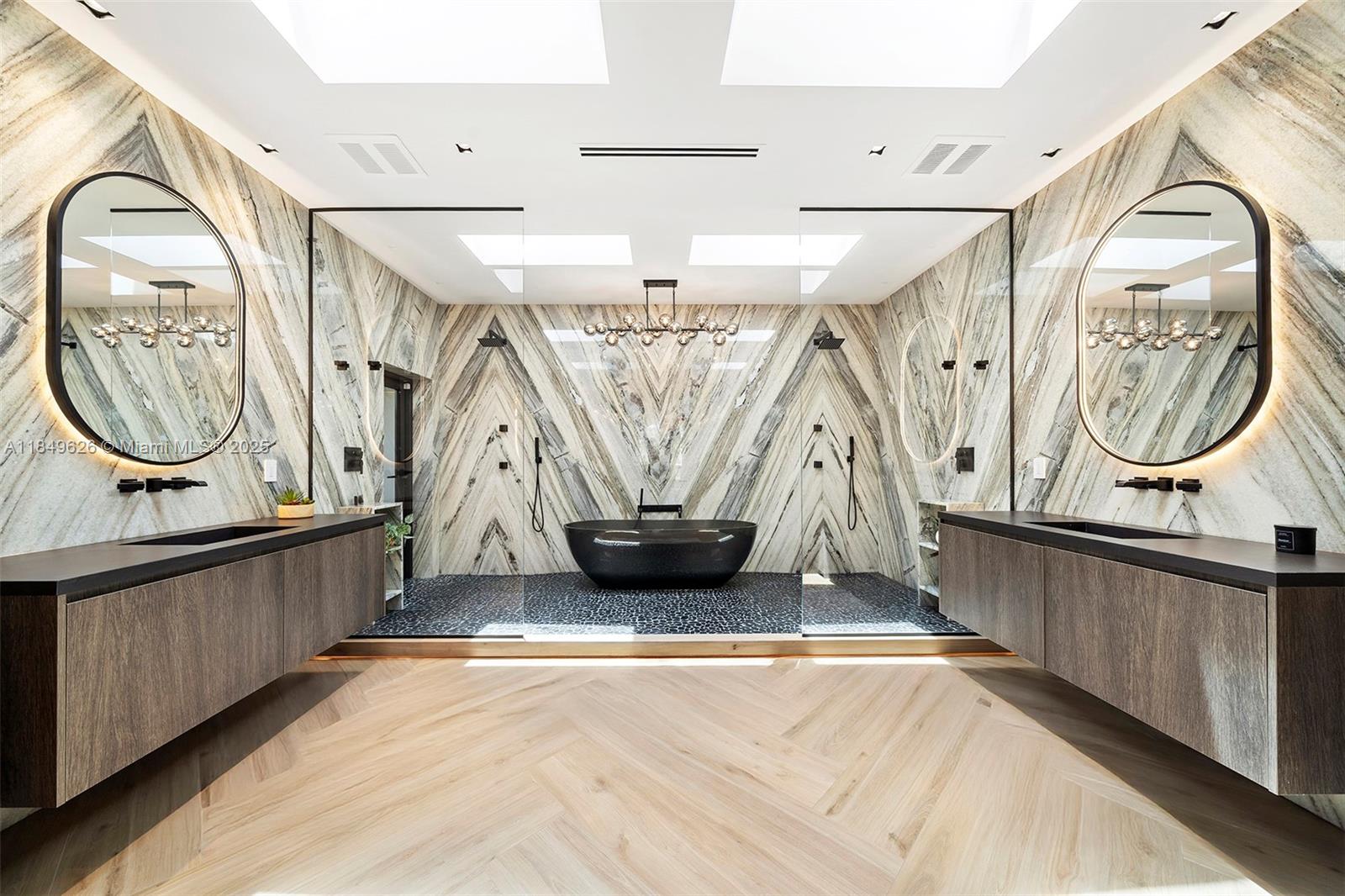 A modern bathroom features a black soaking tub, dual vanities, and dramatic marble wall patterns — FORT LAUDERDALE, FL