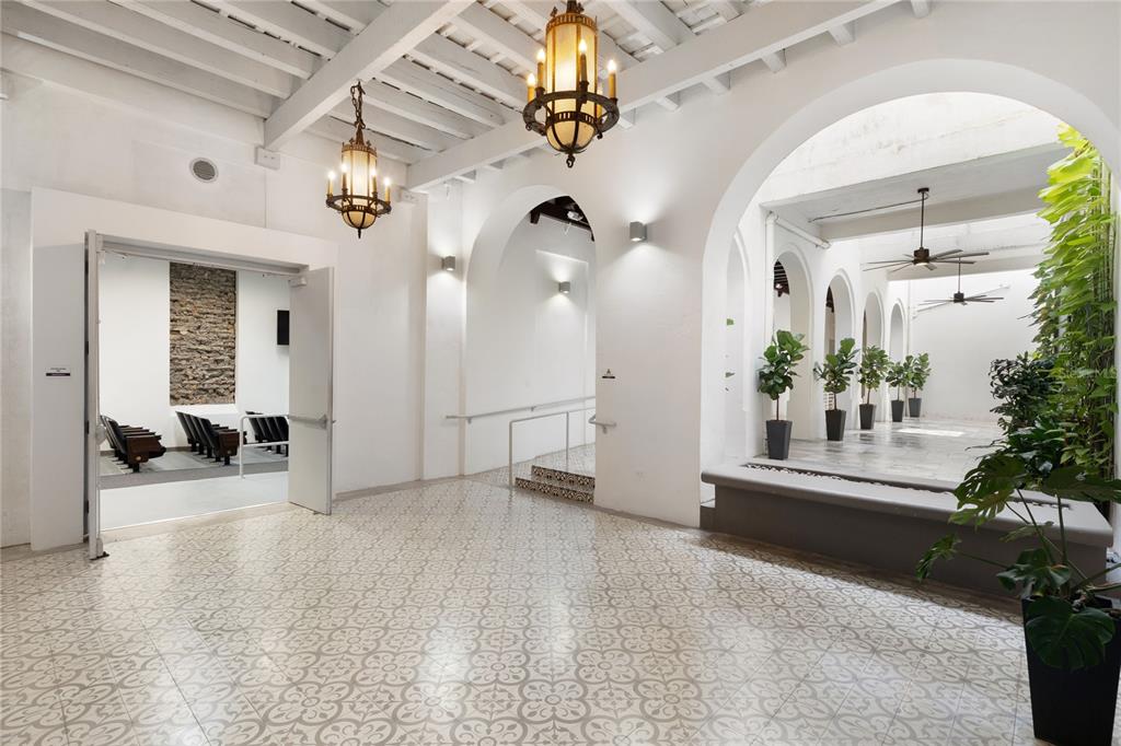 A bright, open-air foyer features patterned tile floors, arched walkways, and hanging lantern-style light fixtures — 205 LUNA, OLD SAN JUAN, PR
