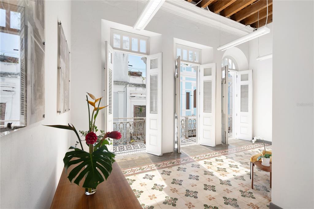 A bright room with patterned tile floors, white walls, and open doors leading to balconies — 205 LUNA, OLD SAN JUAN, PR
