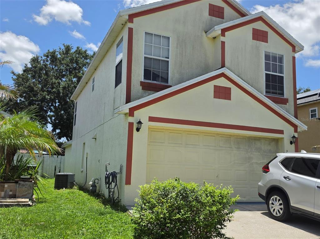 A two-story house with a beige stucco exterior, red trim, and a two-car garage — 2261 BLUE SAPPHIRE CIRCLE, ORLANDO, FL