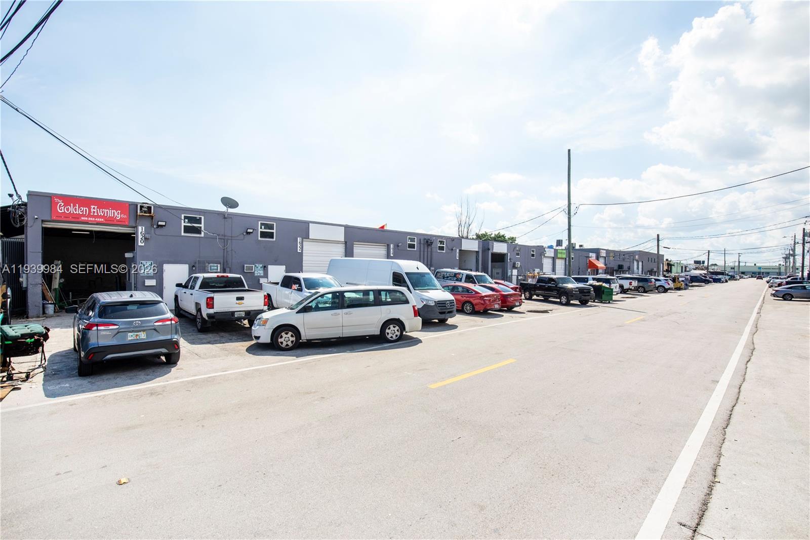 A row of industrial warehouse units with parked vehicles sits along a paved street — 1620 W 31st Pl, Hialeah FL 33012, HIALEAH, FL