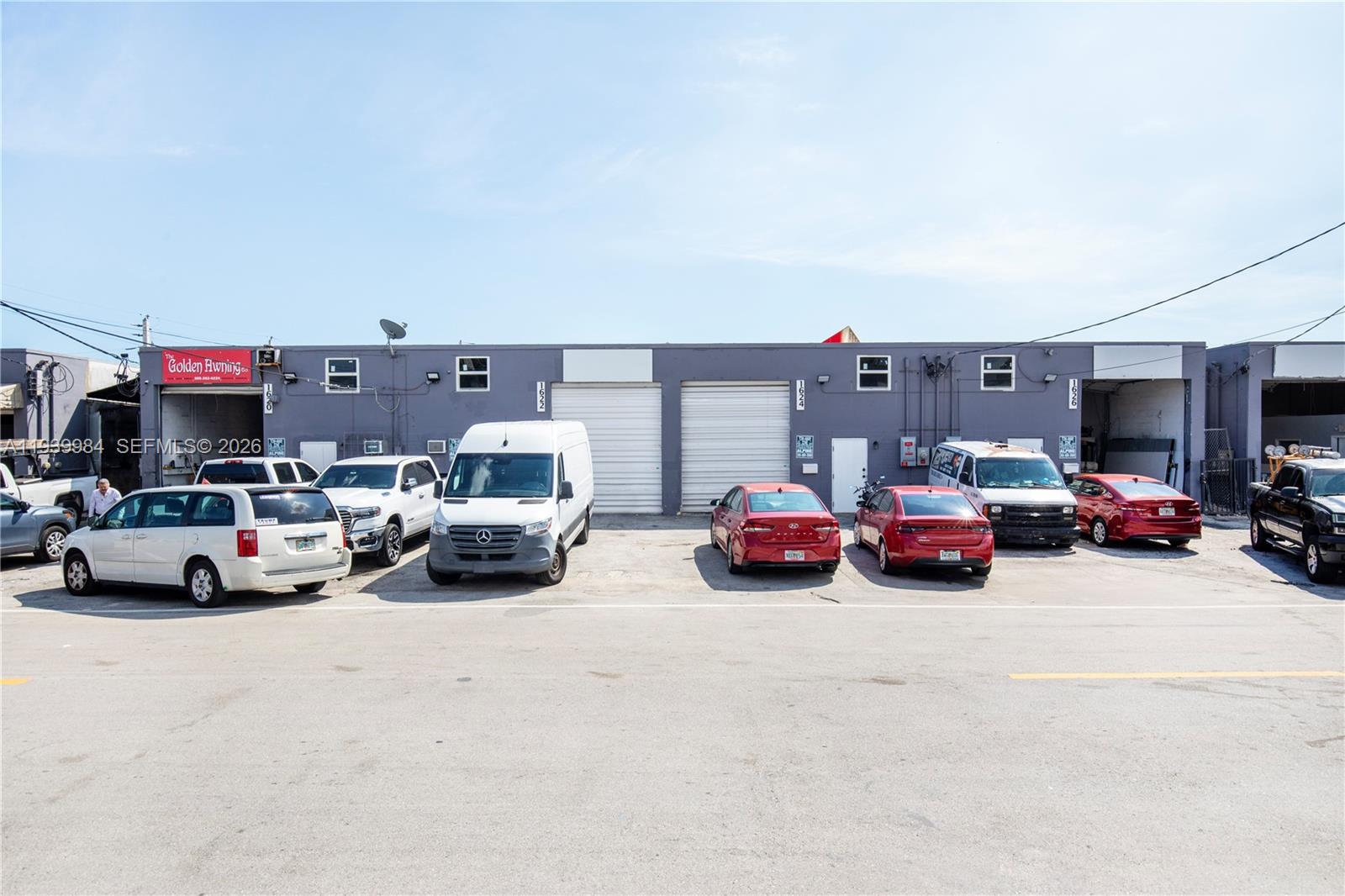A row of commercial warehouse units with roll-up doors and parked vehicles in front — 1620 W 31st Pl, Hialeah FL 33012, HIALEAH, FL