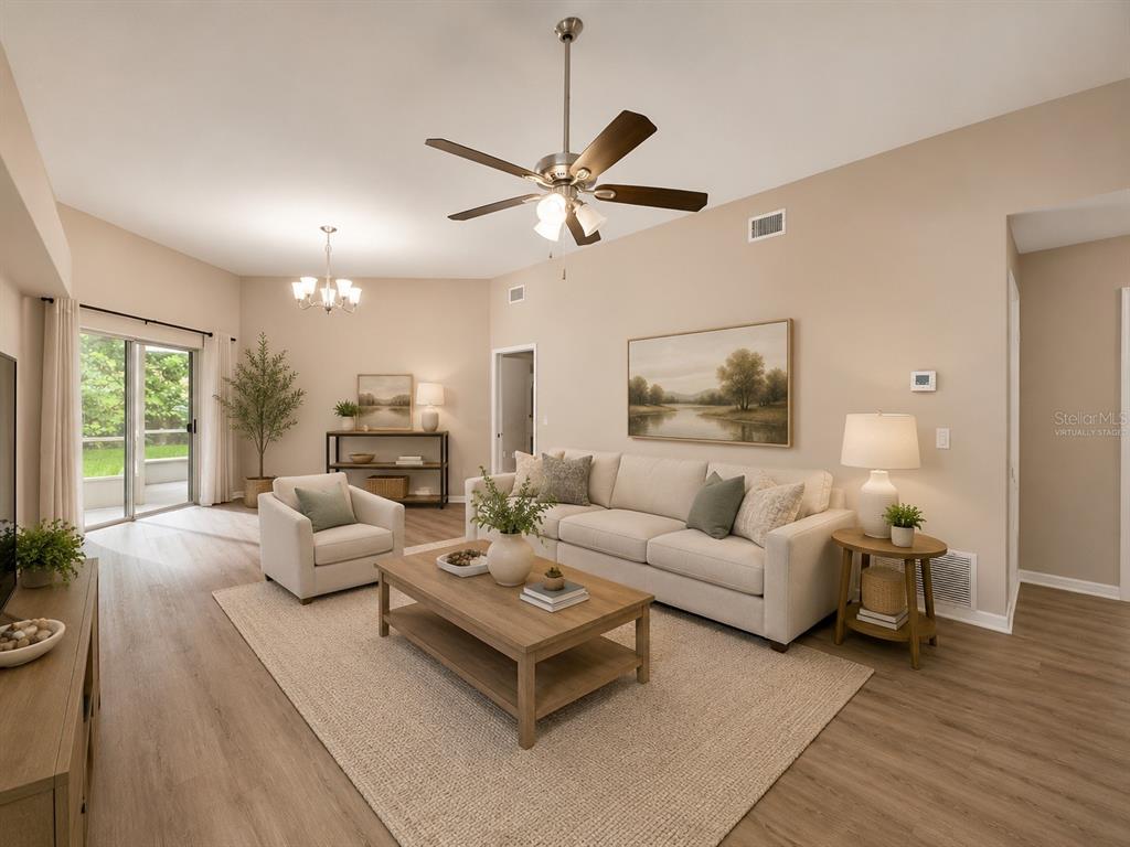 A living room features a beige sofa, armchair, coffee table, and a ceiling fan — 28427 SUNVALE PLACE, WESLEY CHAPEL, FL