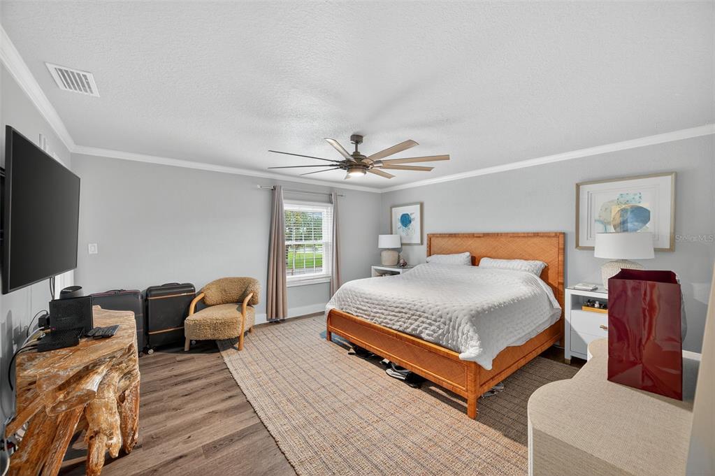 A bedroom features a wooden bed frame, a textured rug, and a rustic wood console — 4924 BEACH DRIVE SE UNIT F, ST PETERSBURG, FL