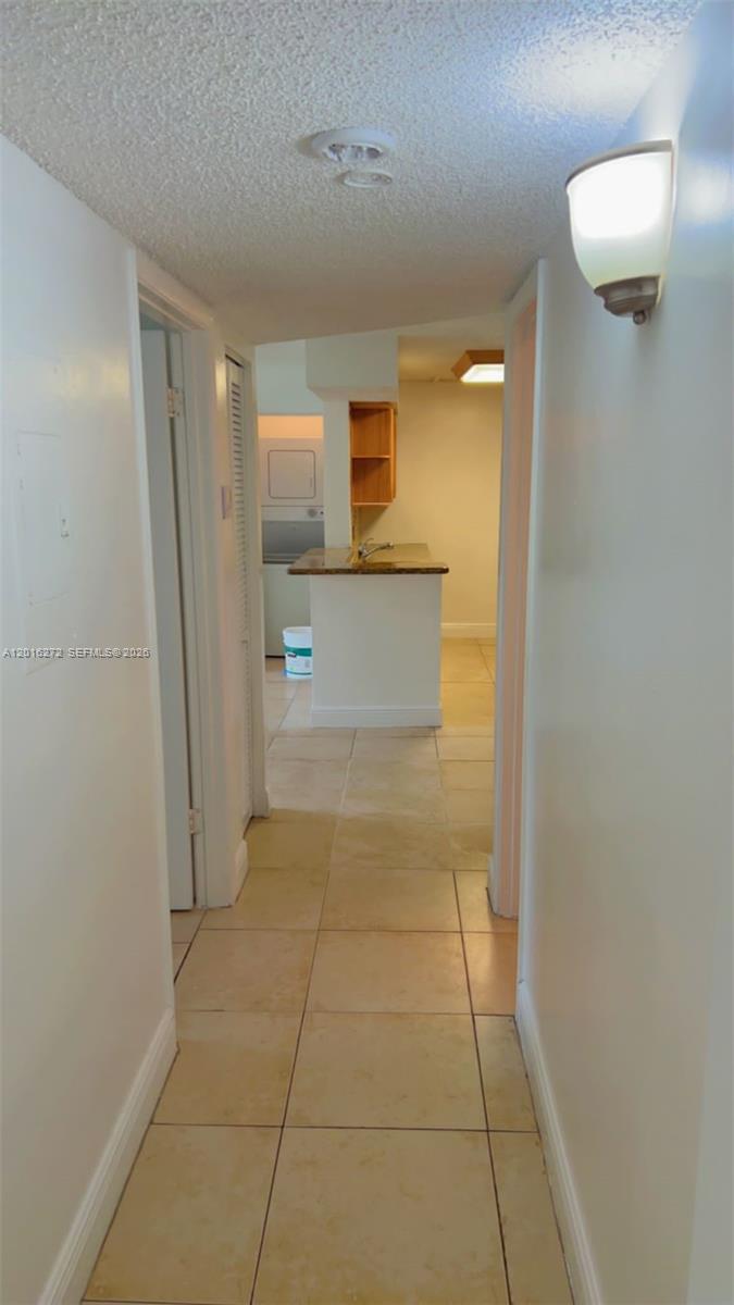 A hallway with tiled floors leads to a kitchen area with a breakfast bar — 1263 SW 46th Ave # 2104, Pompano Beach FL 33069, POMPANO BEACH, FL