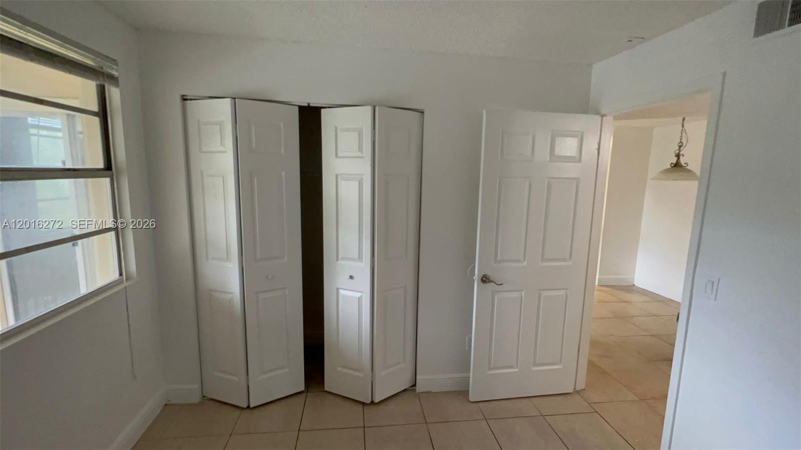 A room with white walls, tile flooring, a closet with bifold doors, and a doorway — 1263 SW 46th Ave # 2104, Pompano Beach FL 33069, POMPANO BEACH, FL