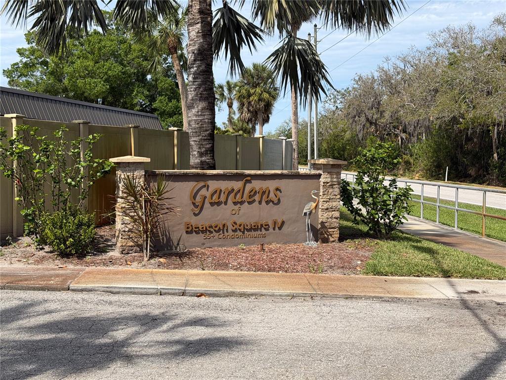 A stone and stucco monument sign marks the entrance to Gardens of Beacon Square IV — 4412 SUNSTATE DRIVE UNIT A, NEW PORT RICHEY, FL