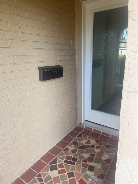 A beige brick wall with a black mailbox next to a glass-paneled door — 4412 SUNSTATE DRIVE UNIT A, NEW PORT RICHEY, FL