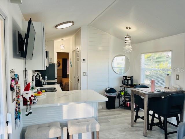 A kitchen with white cabinets, a breakfast bar, and a dining area with a window — 2429 LIMEWOOD AVENUE, CLERMONT, FL