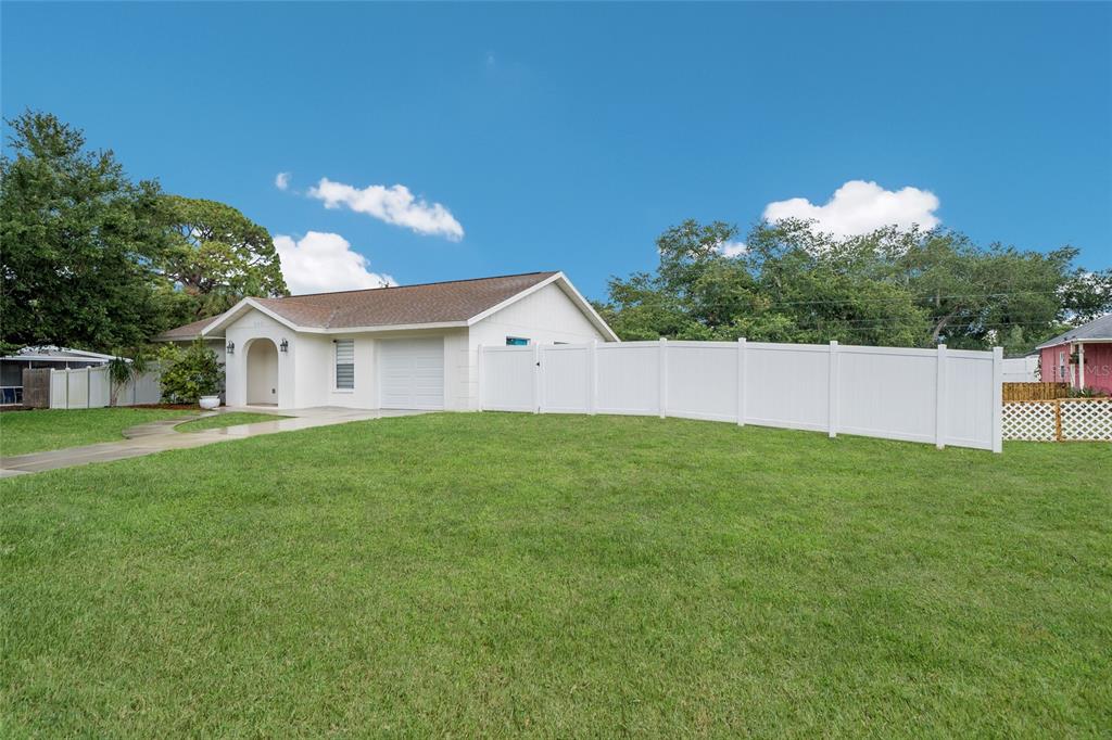 A white single-story house with a garage and a white vinyl fence in the yard — 643 MOBILE ROAD, VENICE, FL
