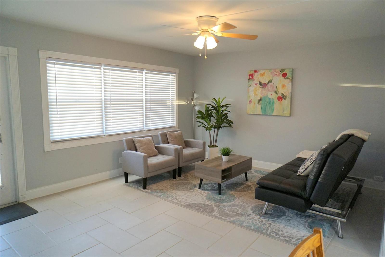 A living room features light gray walls, tile flooring, a ceiling fan, and modern furniture — 4029 Newport # 4029, Deerfield Beach FL 33442, DEERFIELD BEACH, FL