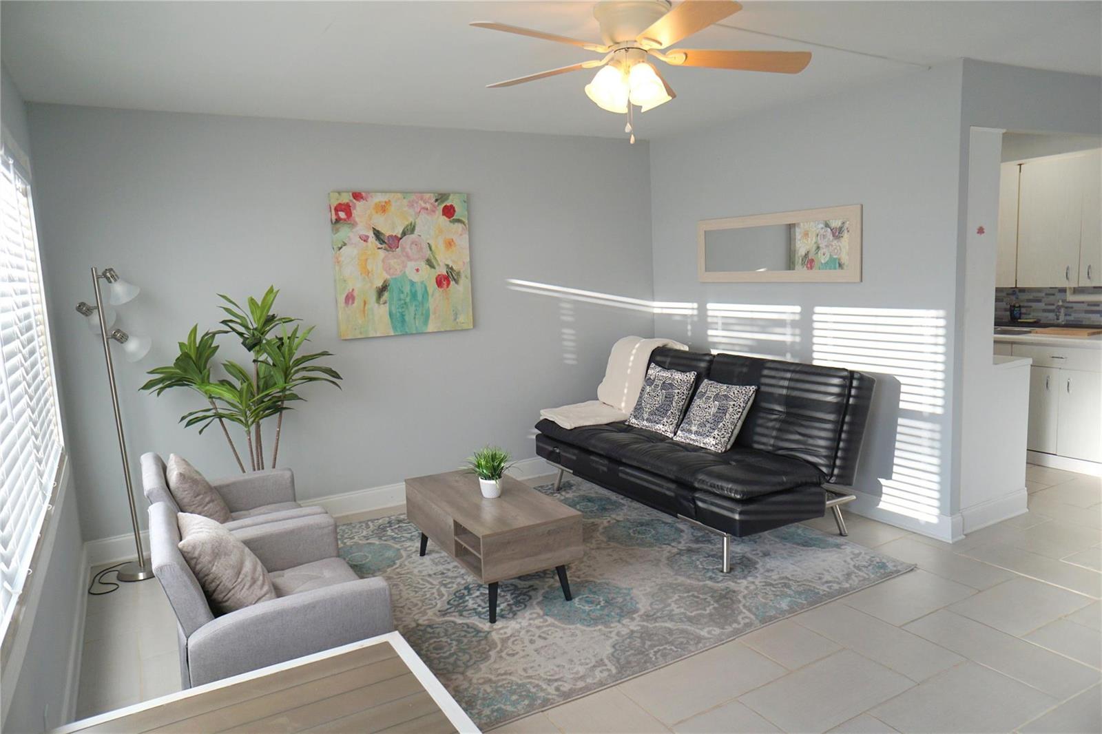 A living room features a black futon, two gray armchairs, and a coffee table — 4029 Newport # 4029, Deerfield Beach FL 33442, DEERFIELD BEACH, FL