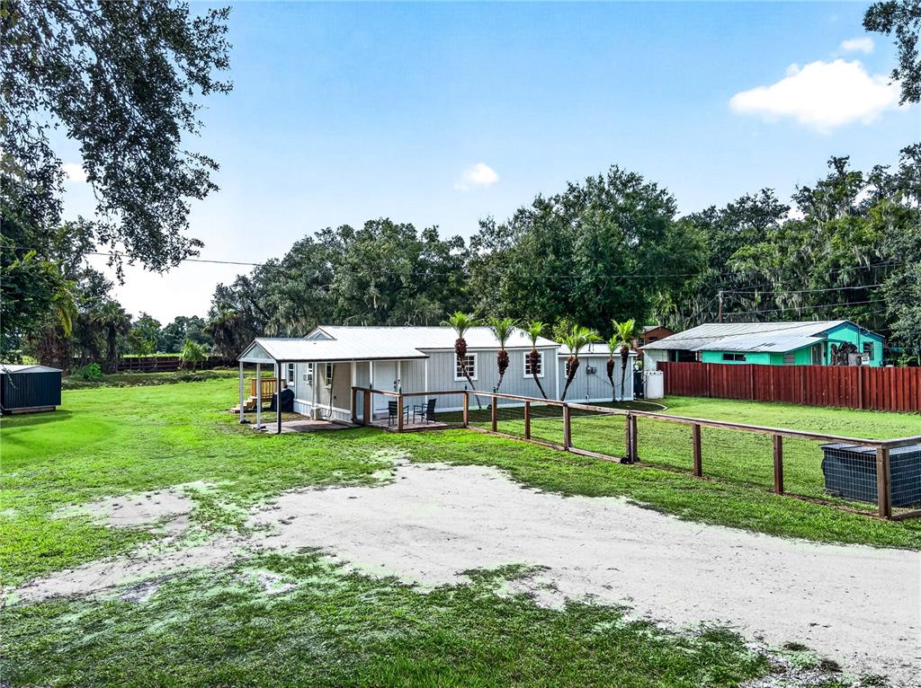 A light gray mobile home sits on a grassy lot with a wooden fence — 2727 SW HIGHWAY 17, ARCADIA, FL