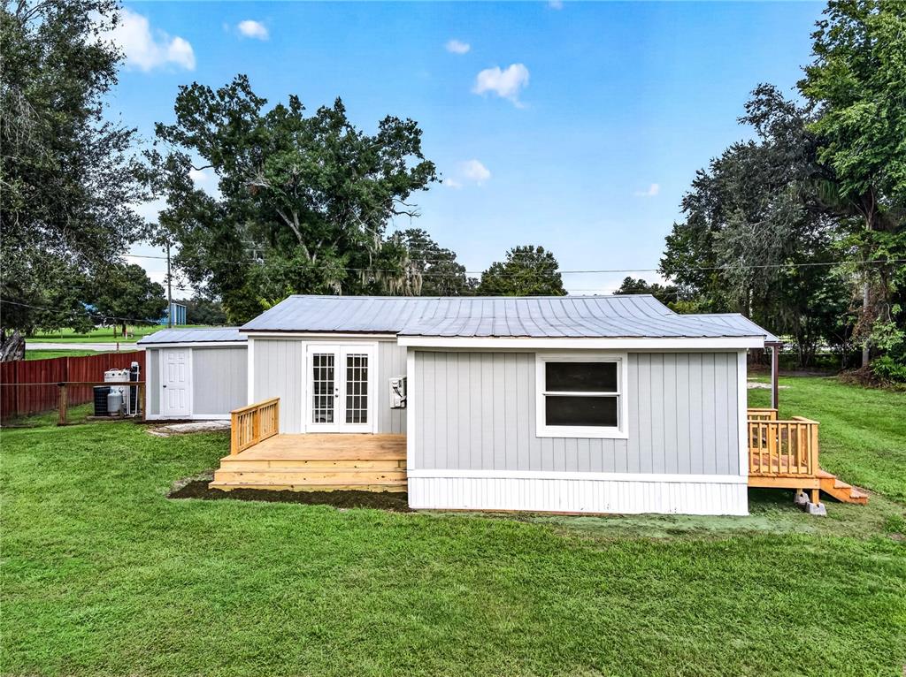 A small, light gray house with a metal roof and two wooden decks — 2727 SW HIGHWAY 17, ARCADIA, FL