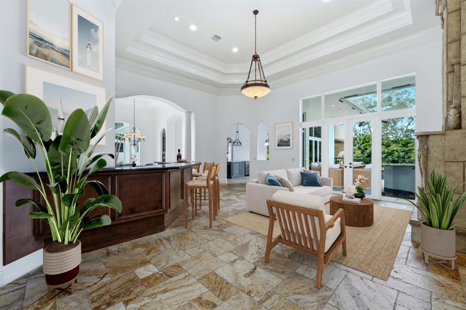A spacious living room features a dark wood bar, stone tile flooring, and glass doors — 608 Inlet Road, North Palm Beach FL 33408, NORTH PALM BEACH, FL