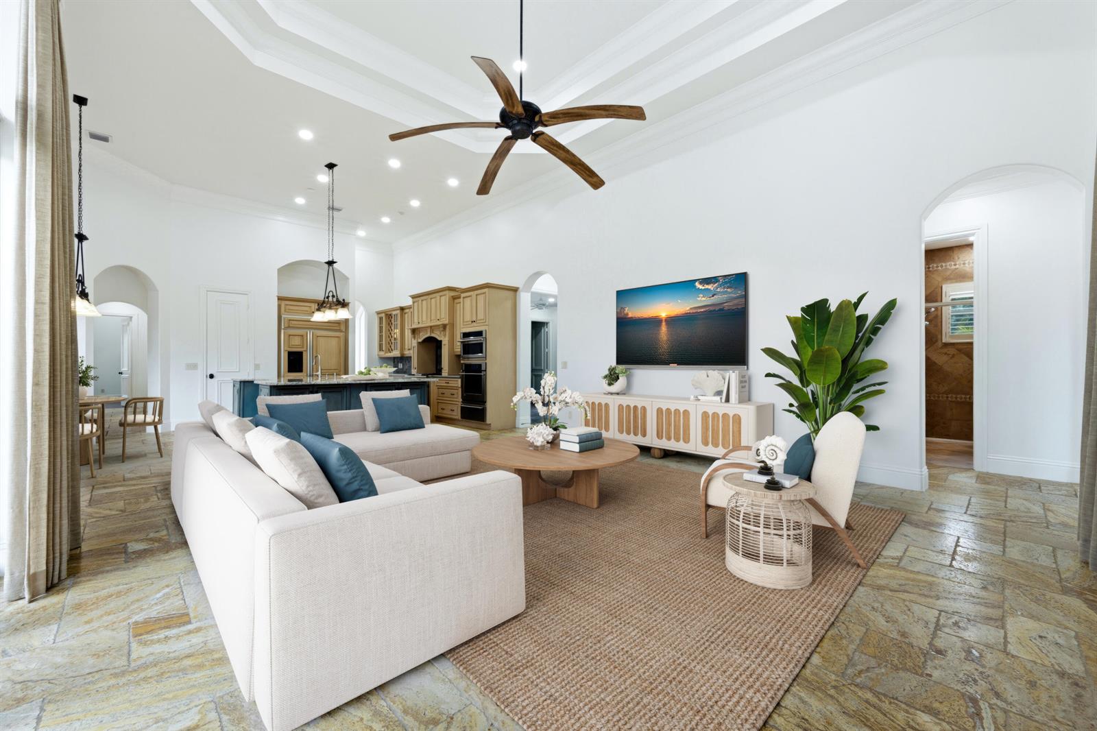 A living room with a large sectional, wooden coffee table, and stone flooring — 608 Inlet Road, North Palm Beach FL 33408, NORTH PALM BEACH, FL