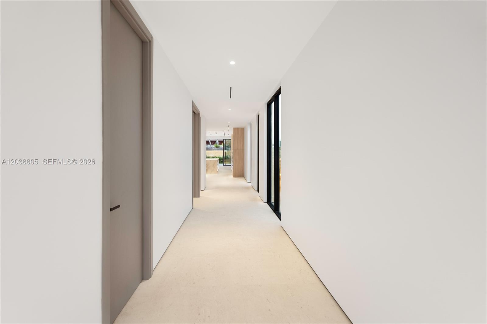 A long, minimalist hallway features white walls, light-colored flooring, and several closed interior doors — 3144 Elizabeth St, Coconut Grove FL 33133, COCONUT GROVE, FL