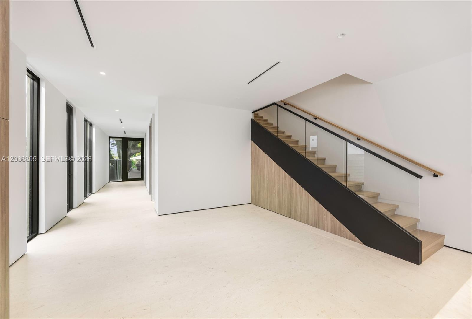 A minimalist hallway features white walls, light flooring, and a modern staircase with glass railings — 3144 Elizabeth St, Coconut Grove FL 33133, COCONUT GROVE, FL