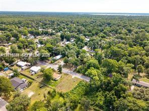An aerial view shows a residential neighborhood with houses surrounded by dense green trees — 0 SE 45 street, Gainesville FL 32641, GAINESVILLE, FL
