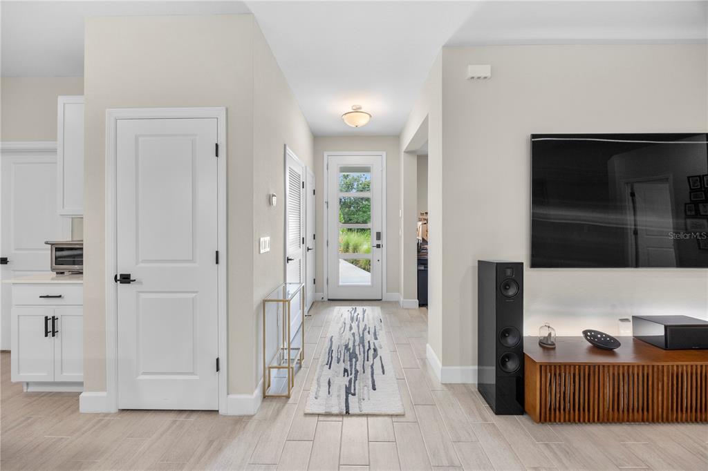 A bright entryway features light tile flooring, a glass-paneled front door, and a runner rug — 4916 HADER ROAD, NORTH PORT, FL