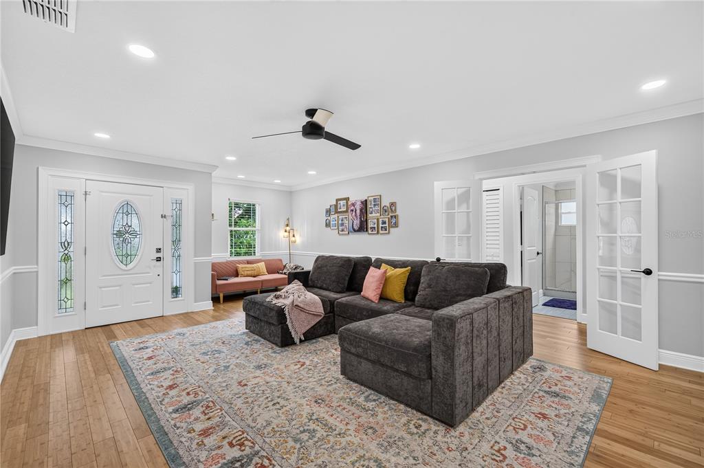 A living room features a dark gray sectional sofa, a patterned rug, and white doors — 2028 ILLINOIS STREET, ORLANDO, FL