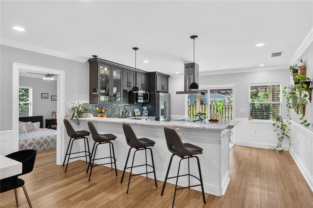 A kitchen with dark cabinets, a white breakfast bar, and wood flooring — 2028 ILLINOIS STREET, ORLANDO, FL