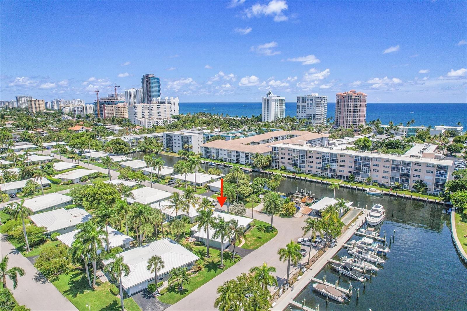 An aerial view shows a residential neighborhood with a canal, boat slips, and high-rise buildings — 1431 S Ocean Boulevard # 74, Pompano Beach FL 33062, POMPANO BEACH, FL