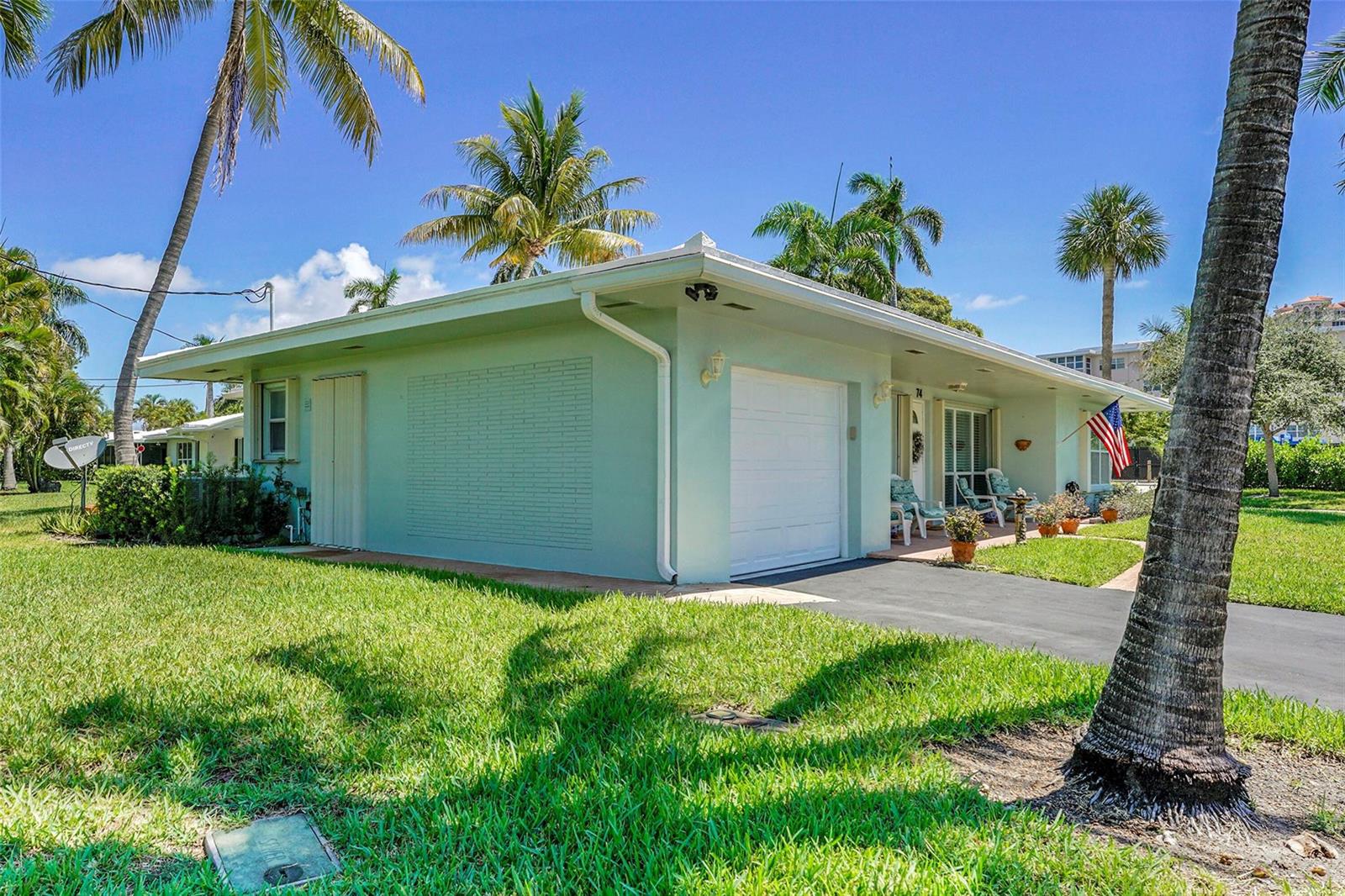 A light green single-story house with a white garage door and a palm-lined front yard — 1431 S Ocean Boulevard # 74, Pompano Beach FL 33062, POMPANO BEACH, FL