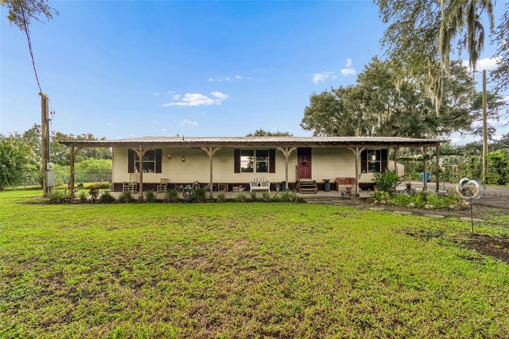 A single-story house with a covered front porch sits on a grassy lawn — 4404 PLATT ROAD, PLANT CITY, FL
