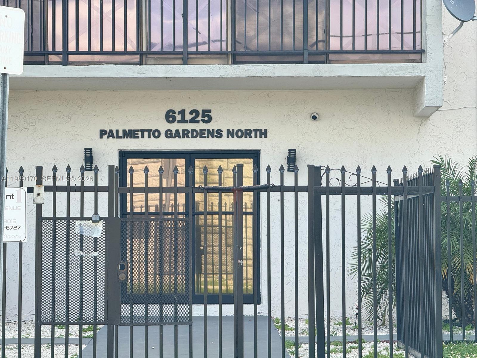 A kitchen features white cabinets, a marble-patterned backsplash, and a white refrigerator with magnets — 6125 W 20th Ave # 306, Hialeah FL 33012, HIALEAH, FL