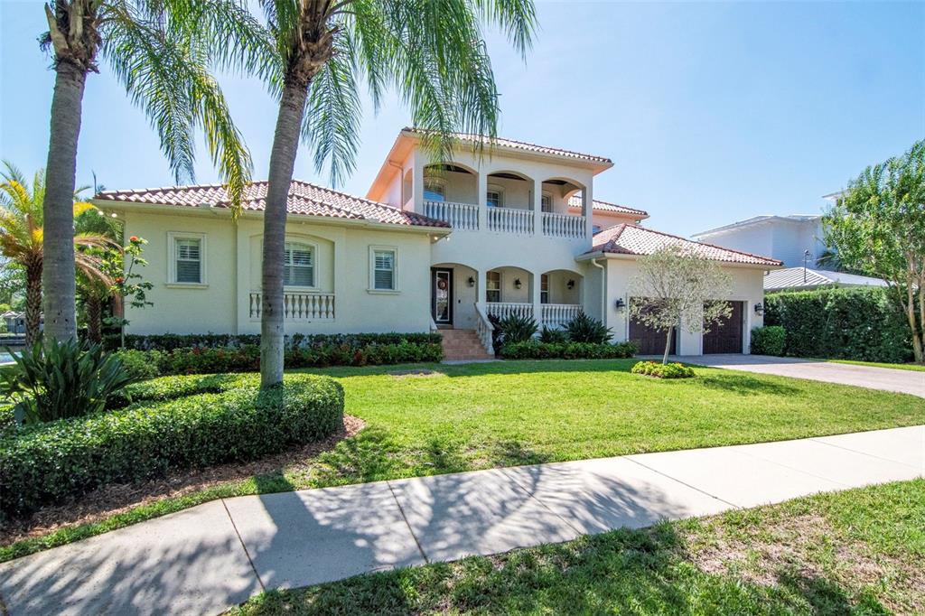A two-story Mediterranean-style house with a tile roof, arched balconies, and a manicured lawn — 2212 S OCCIDENT STREET, TAMPA, FL
