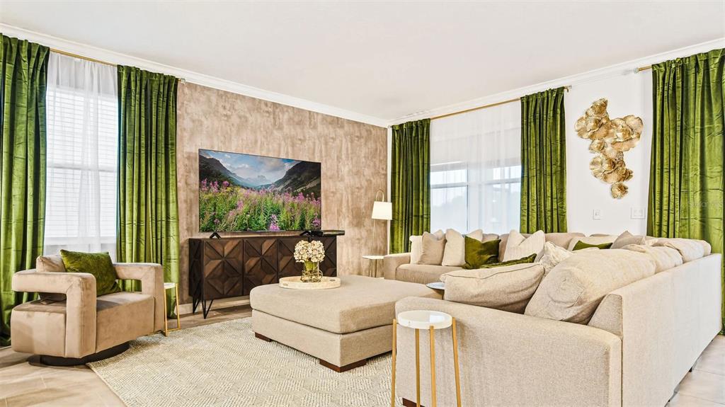 A living room features a large sectional sofa, a television, and green velvet curtains — 2993 PROTAGONIST STREET, KISSIMMEE, FL