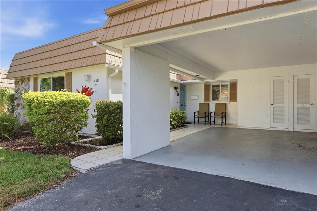 A single-story residence features a covered carport, a small front patio, and tan roof shingles — 2713 RIVERBLUFF COURT UNIT V101, SARASOTA, FL
