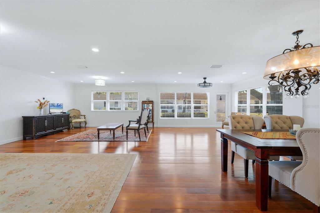 A spacious, open-concept living and dining area features hardwood floors, recessed lighting, and large windows — 2713 RIVERBLUFF COURT UNIT V101, SARASOTA, FL