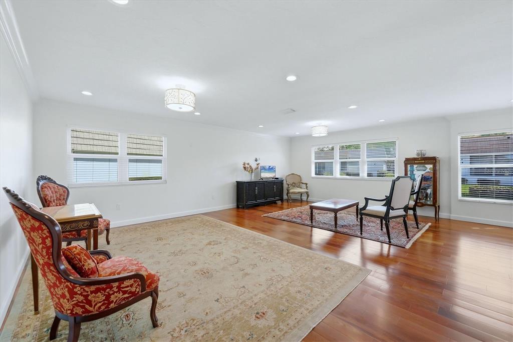 A spacious living room features hardwood floors, two area rugs, and traditional furniture — 2713 RIVERBLUFF COURT UNIT V101, SARASOTA, FL