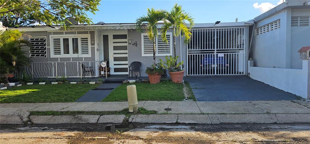 A single-story house with a white-trimmed facade, a gated carport, and a front lawn — 33 S BAIROA AVE STREET S UNIT AF 2, CAGUAS, PR