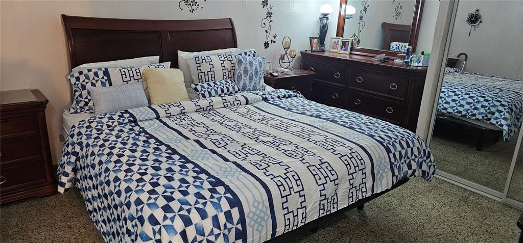 A bedroom features a bed with a blue and white patterned comforter and wooden furniture — 33 S BAIROA AVE STREET S UNIT AF 2, CAGUAS, PR