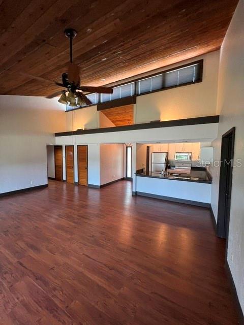 An open-concept living area features a wood-plank ceiling, dark flooring, and an elevated kitchen — 808 PINEWOOD COURT UNIT 3138/9, HAINES CITY, FL