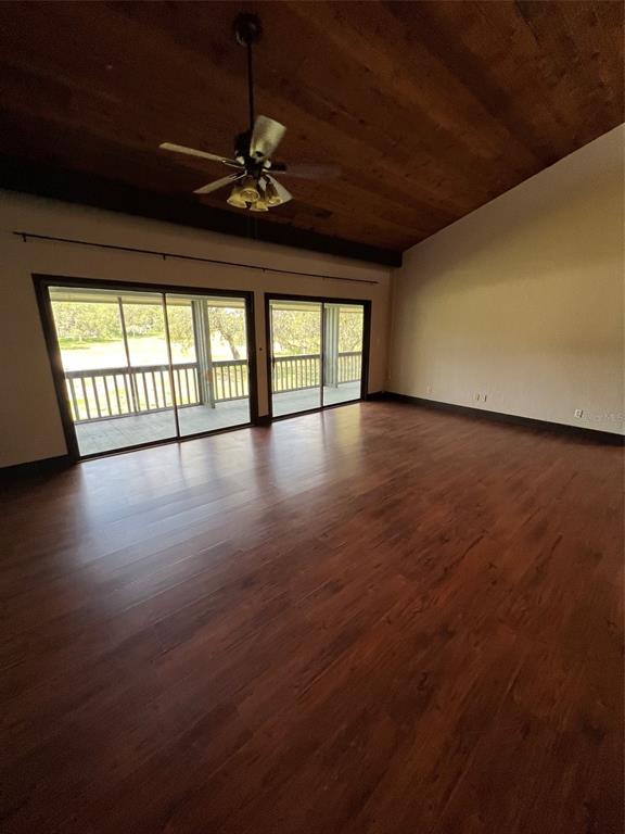 A spacious room features dark wood flooring, a vaulted wood-paneled ceiling, and sliding glass doors — 808 PINEWOOD COURT UNIT 3138/9, HAINES CITY, FL