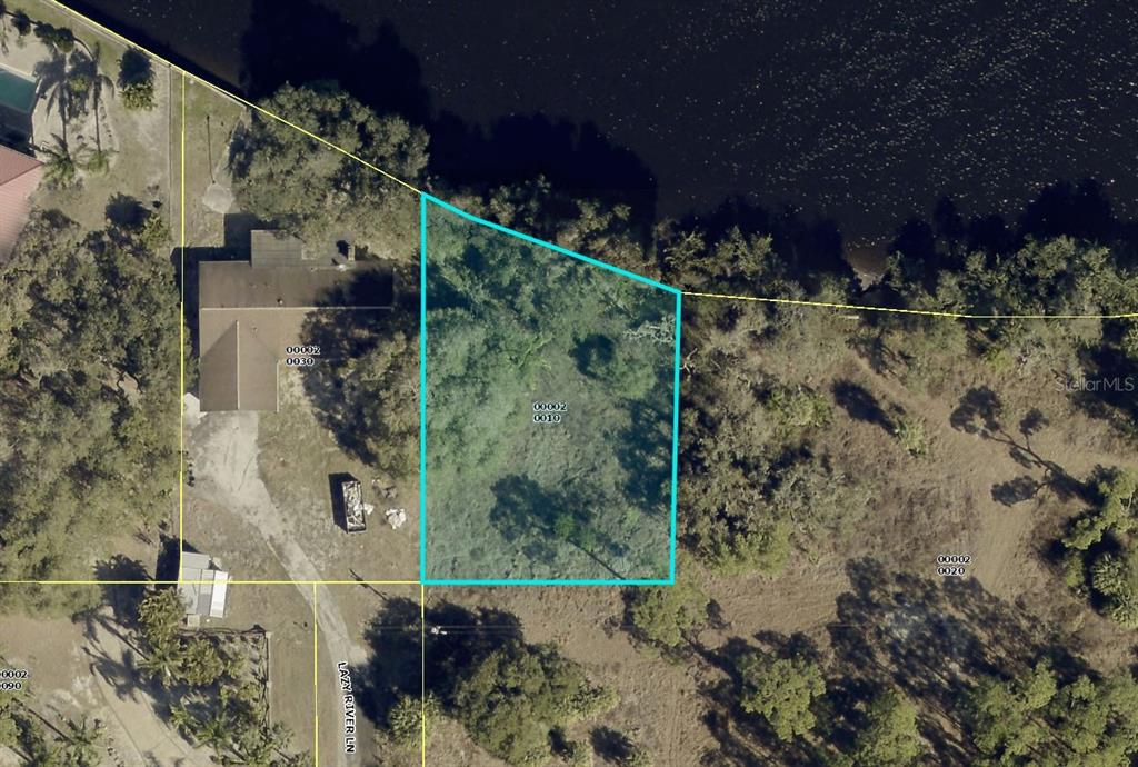 This is an aerial map showing a highlighted vacant waterfront lot next to a house — 2330 & 2318 LAZY RIVER LANE, FORT MYERS, FL
