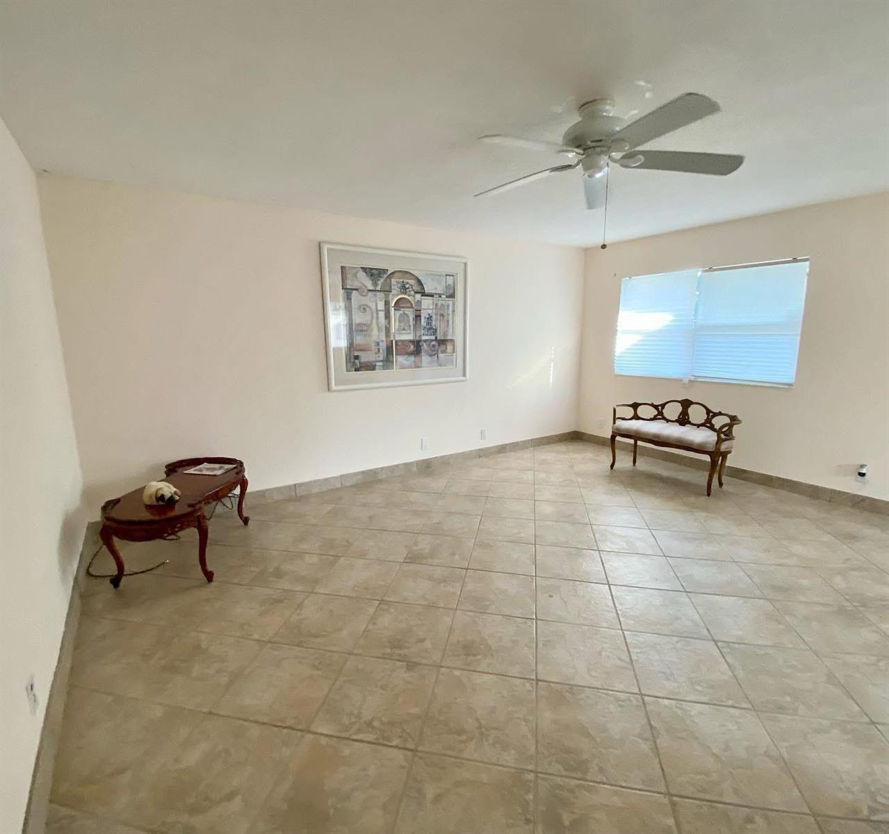 A room with beige walls, tile flooring, a ceiling fan, and two pieces of furniture — 568 Brittany L, Delray Beach FL 33446, DELRAY BEACH, FL